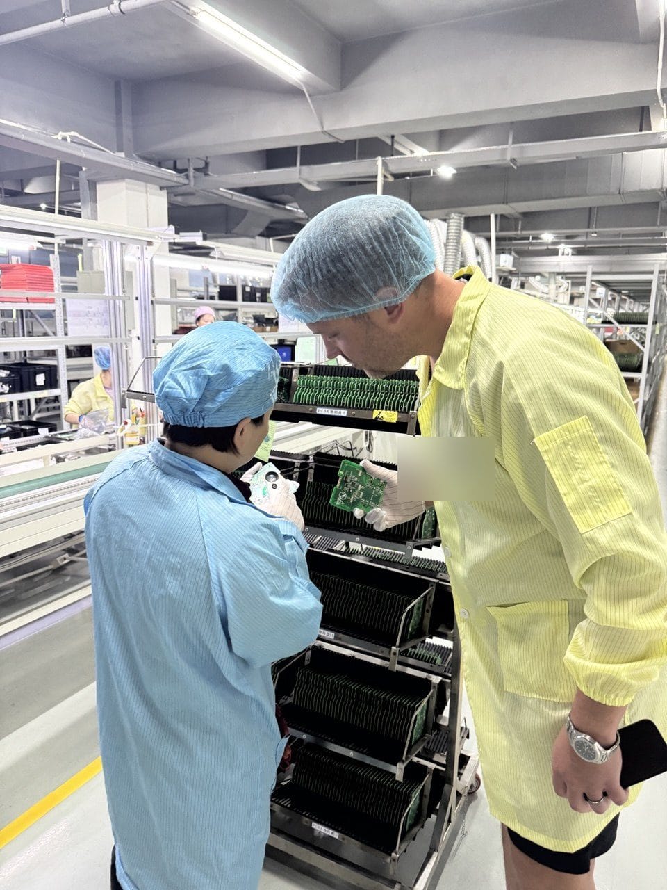 Union Delta team inspecting an assembled board with a line operator on the factory floor