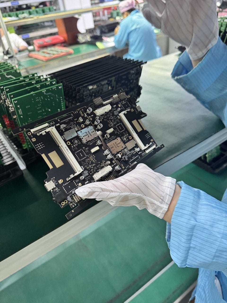 A dense multi-socket RF motherboard held in an ESD glove